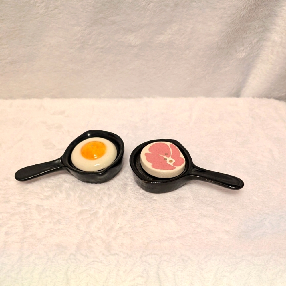 Vintage salt and pepper shakers. Frying pan of ham slab and eggs